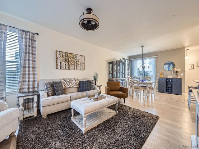 3921 E 141st Ave, Thornton, CO 80602 - living area featuring a chandelier and light wood-style flooring
