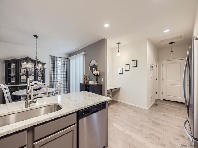 3921 E 141st Ave, Thornton, CO 80602 - kitchen with stainless steel appliances, a chandelier, a sink, gray cabinetry, and decorative light fixtures