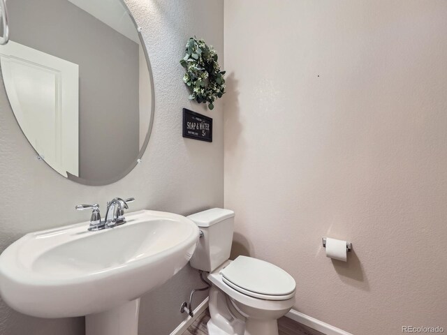 3921 E 141st Ave, Thornton, CO 80602 - bathroom featuring a sink, wood finished floors, and toilet