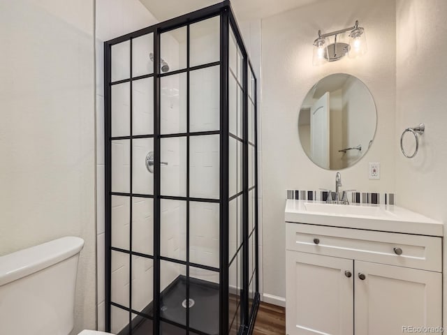 3921 E 141st Ave, Thornton, CO 80602 - bathroom featuring vanity, a stall shower, wood finished floors, and toilet