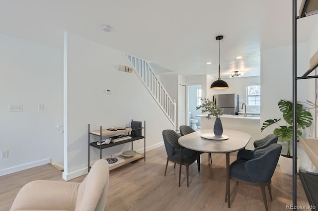 dining area featuring stairway, recessed lighting, baseboards, and light wood finished floors