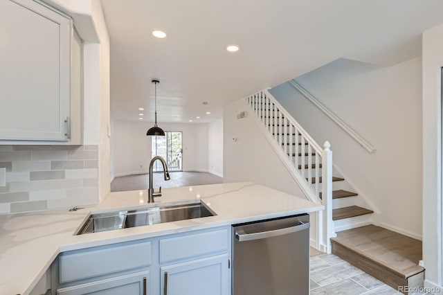 kitchen featuring a sink, dishwasher, recessed lighting, a peninsula, and decorative backsplash