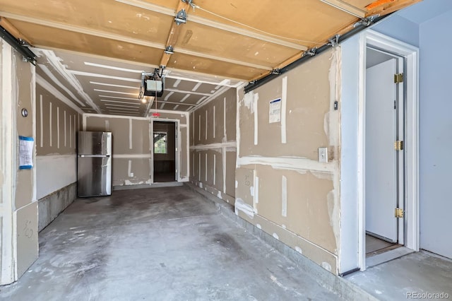 garage with freestanding refrigerator and a garage door opener