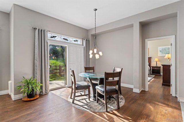 dining space with wood finished floors, baseboards, and a chandelier