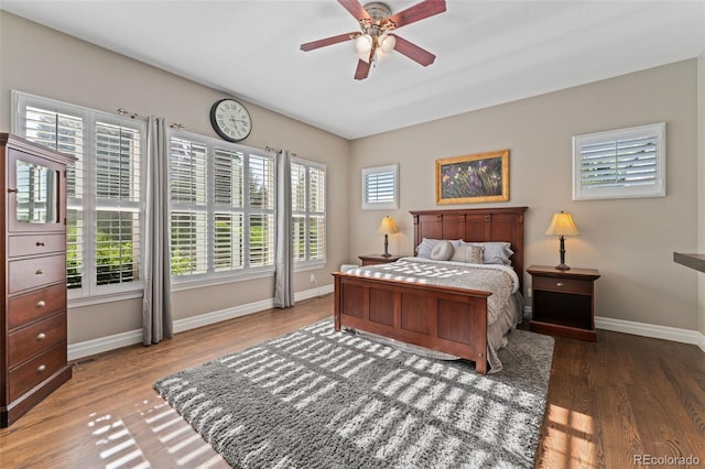 bedroom featuring baseboards, wood finished floors, and a ceiling fan