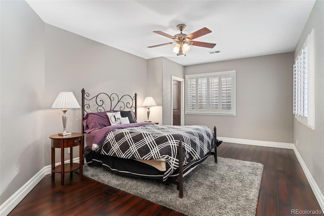 bedroom featuring baseboards, wood-type flooring, and multiple windows