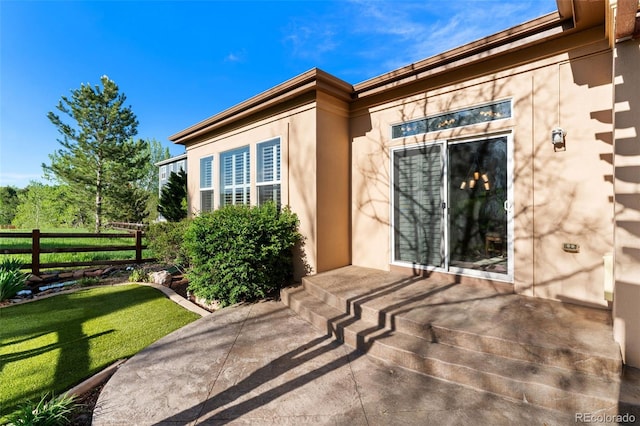 doorway to property featuring stucco siding