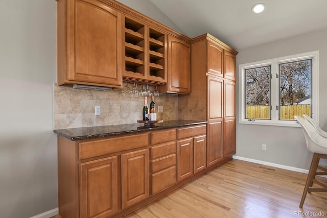 3785 E 134th Ct, Thornton, CO 80241 - kitchen featuring decorative backsplash, brown cabinets, light wood-type flooring, recessed lighting, and lofted ceiling
