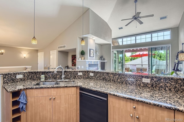 kitchen with a sink, black dishwasher, dark stone countertops, open floor plan, and ceiling fan