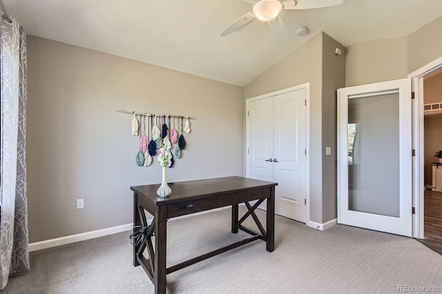 office featuring ceiling fan, vaulted ceiling, baseboards, and light carpet