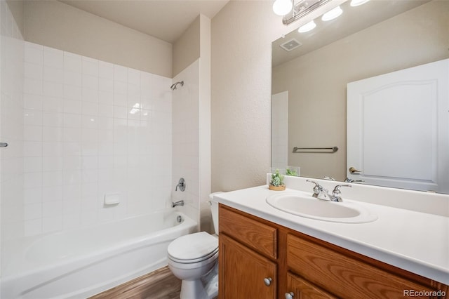 bathroom featuring shower / bathtub combination, visible vents, toilet, vanity, and wood finished floors