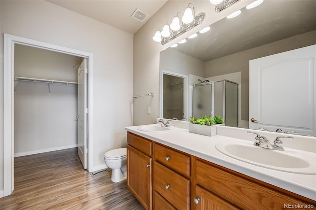 full bath featuring a stall shower, visible vents, a sink, and double vanity