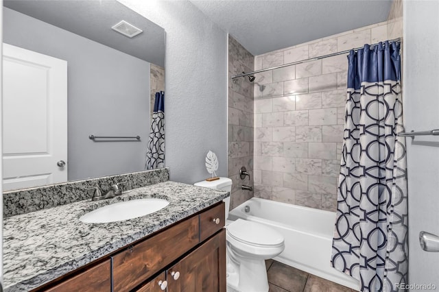 full bathroom featuring shower / tub combo with curtain, toilet, a textured ceiling, vanity, and tile patterned flooring