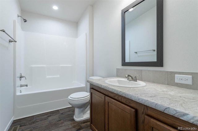 full bathroom featuring vanity, hardwood / wood-style flooring, tub / shower combination, and toilet