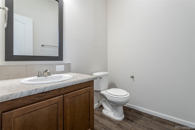 bathroom with wood-type flooring, vanity, and toilet