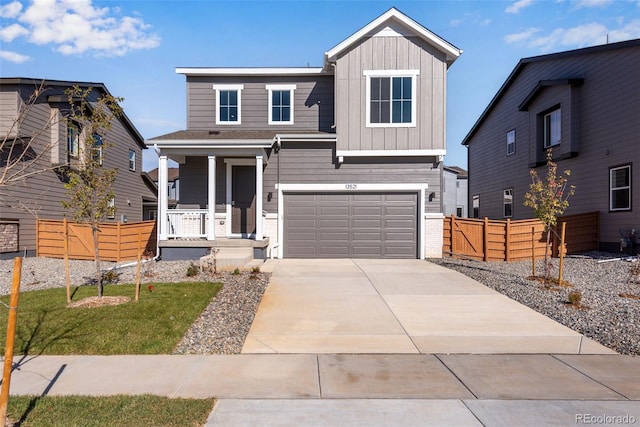 view of front of house with covered porch, fence, board and batten siding, driveway, and a garage