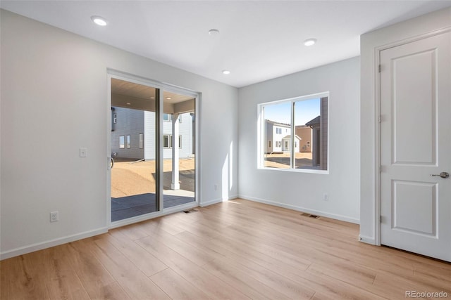 unfurnished room featuring plenty of natural light, wood finished floors, baseboards, and recessed lighting