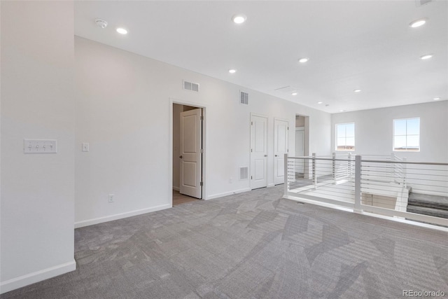 spare room featuring carpet flooring, baseboards, and recessed lighting