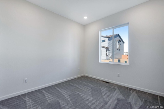 spare room featuring dark colored carpet, baseboards, and recessed lighting