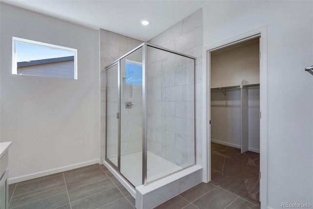 bathroom with tile patterned flooring, vanity, and a shower with door