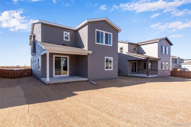 rear view of property with a patio, fence, and roof with shingles