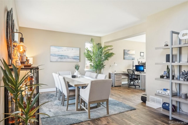 dining area with visible vents, baseboards, and wood finished floors