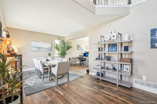 dining room with wood finished floors, visible vents, and baseboards