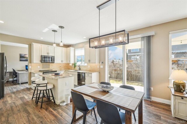 dining area with dark wood-style floors, recessed lighting, and baseboards