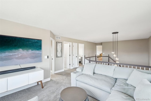 living room featuring visible vents, baseboards, and light colored carpet