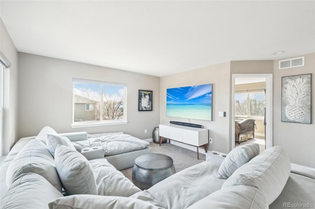 living area featuring visible vents, baseboards, and carpet