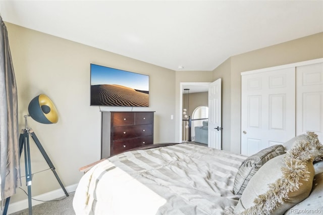 carpeted bedroom with a closet and baseboards