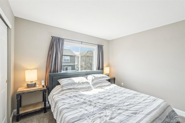 carpeted bedroom featuring a closet and baseboards