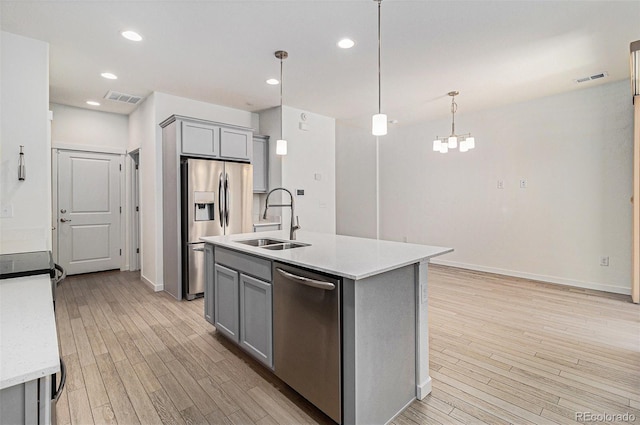 9757 Ash Ln, Thornton, CO 80229 - kitchen with stainless steel appliances, gray cabinets, a sink, light wood-style flooring, and recessed lighting