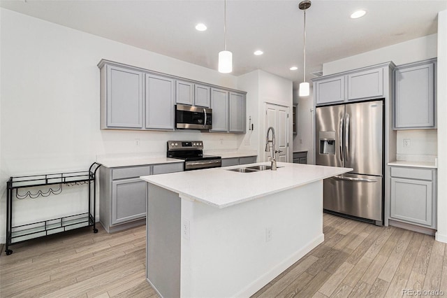 9757 Ash Ln, Thornton, CO 80229 - kitchen featuring stainless steel appliances, gray cabinets, a sink, light wood-style floors, and recessed lighting