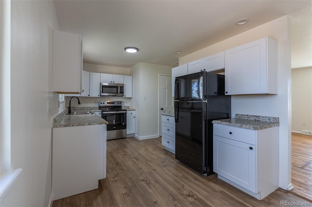 6013 W 62nd Ave, Arvada, CO 80033 - kitchen featuring stainless steel appliances, a sink, dark wood-type flooring, baseboards, and white cabinets