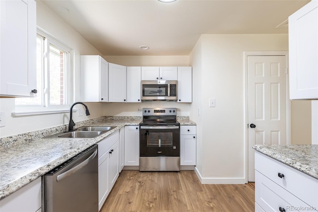 6013 W 62nd Ave, Arvada, CO 80033 - kitchen with stainless steel appliances, a sink, light wood-style flooring, and white cabinets