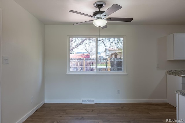 6013 W 62nd Ave, Arvada, CO 80033 - unfurnished dining area with ceiling fan, dark wood-style floors, and baseboards
