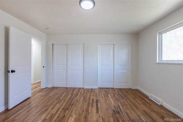 6013 W 62nd Ave, Arvada, CO 80033 - unfurnished bedroom with multiple closets, wood finished floors, and baseboards