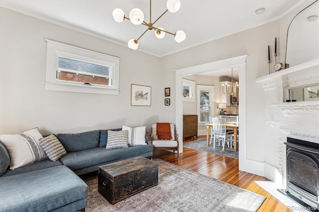 living room with ornamental molding, a chandelier, and hardwood / wood-style floors