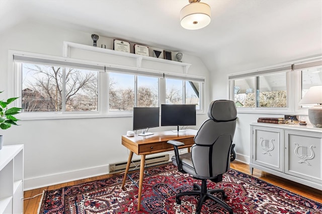 office space featuring vaulted ceiling, hardwood / wood-style floors, and baseboard heating