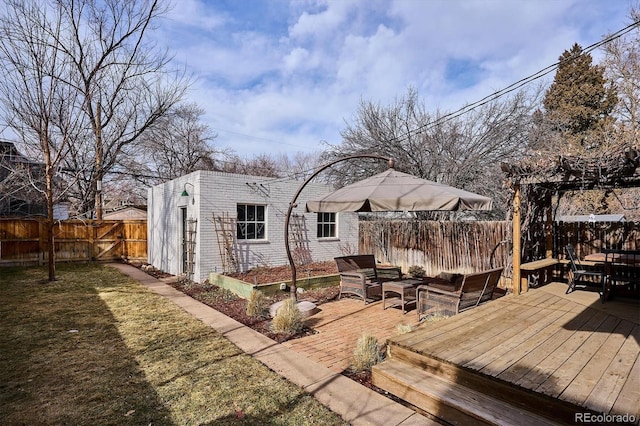 rear view of house featuring an outdoor hangout area, an outbuilding, a lawn, and a deck