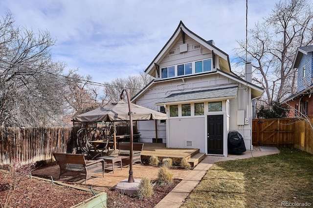 rear view of property featuring a deck and a lawn