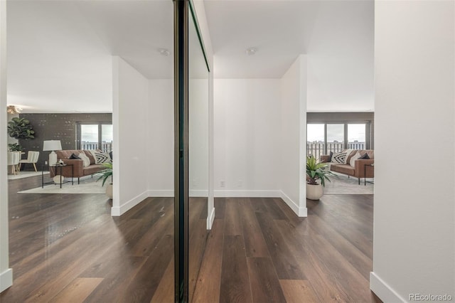 interior space featuring dark wood-type flooring and baseboards