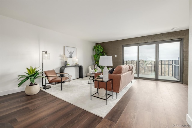 living area with visible vents, baseboards, and wood finished floors