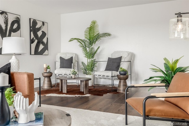 sitting room with baseboards and wood finished floors