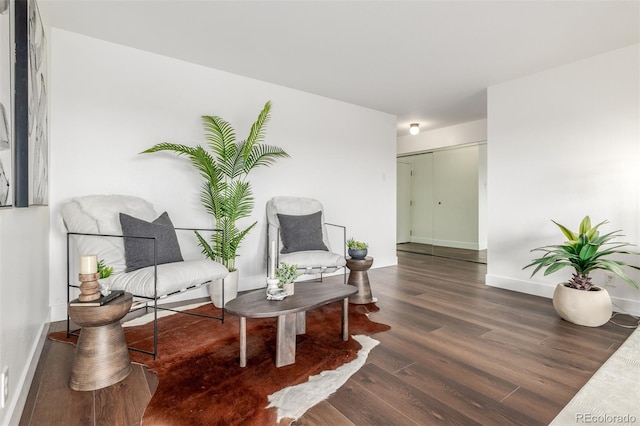 living area with baseboards and wood finished floors