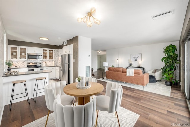 dining room featuring visible vents and wood finished floors