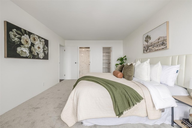 bedroom featuring ensuite bath and carpet