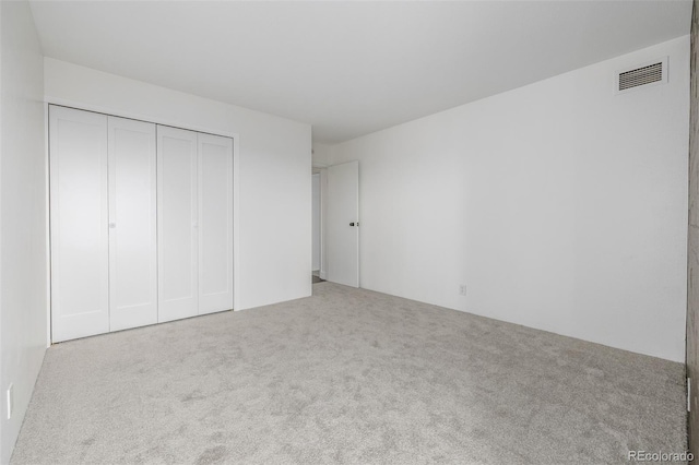 unfurnished bedroom featuring visible vents, carpet, and a closet