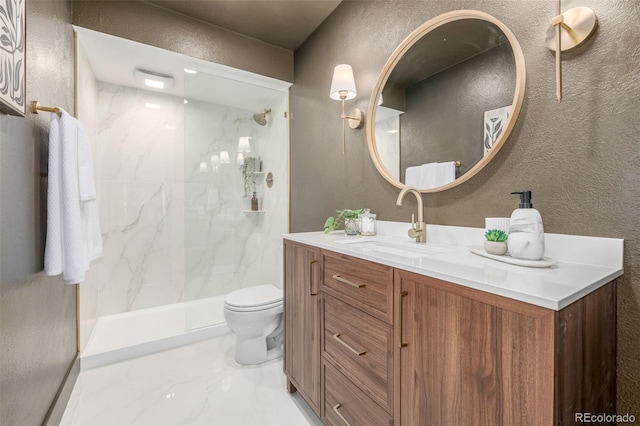 bathroom featuring a marble finish shower, toilet, vanity, and a textured wall